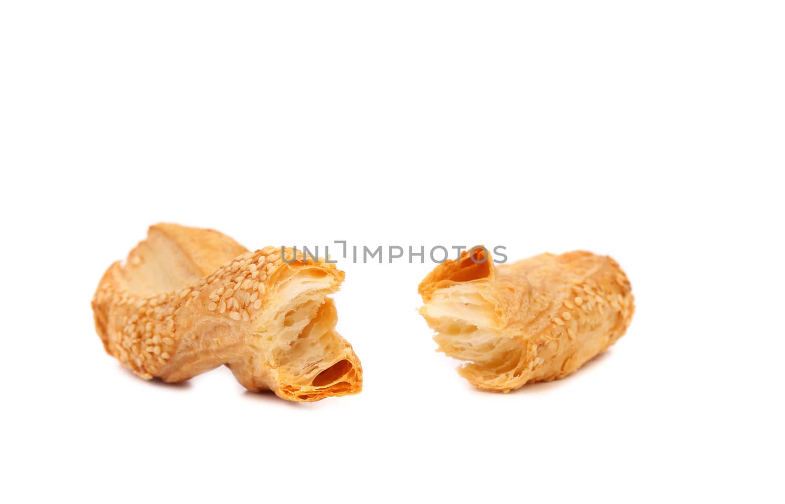Broken cheese stick cracker with sesame seeds. White background.