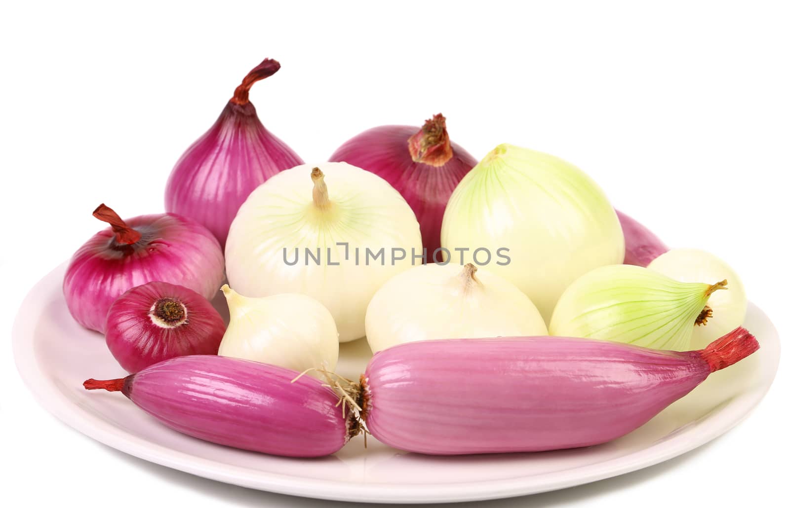 Different onions on a plate. White background.