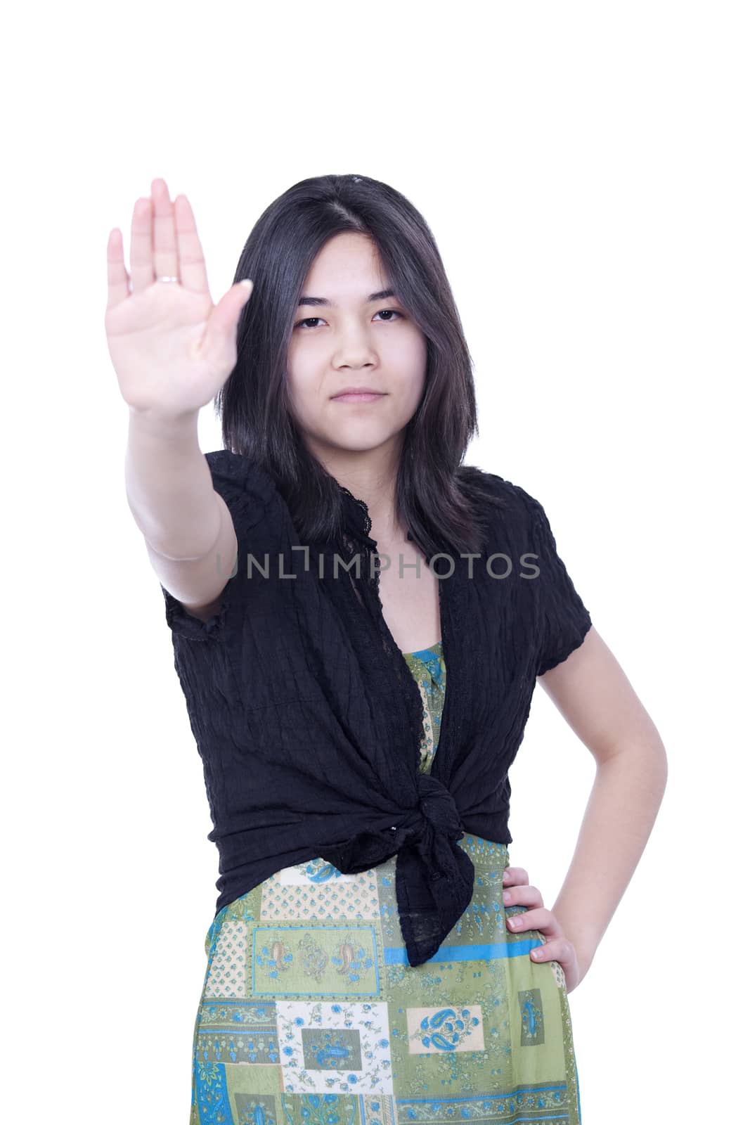 Young biracial teen girl putting hands up to say 'stop', one hand on hip