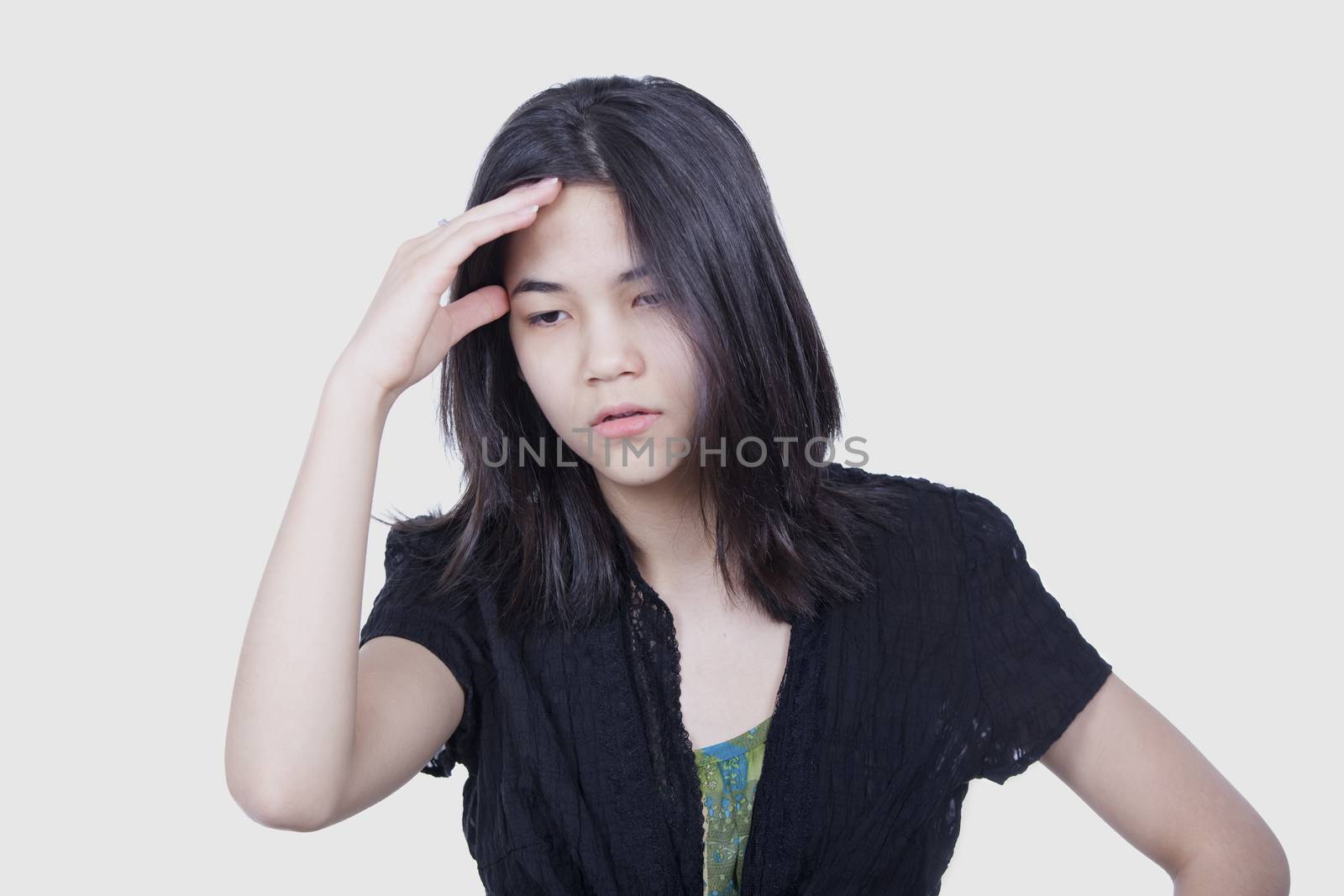 Young biracial teen girl massaging temple, face stressed or havi by jarenwicklund