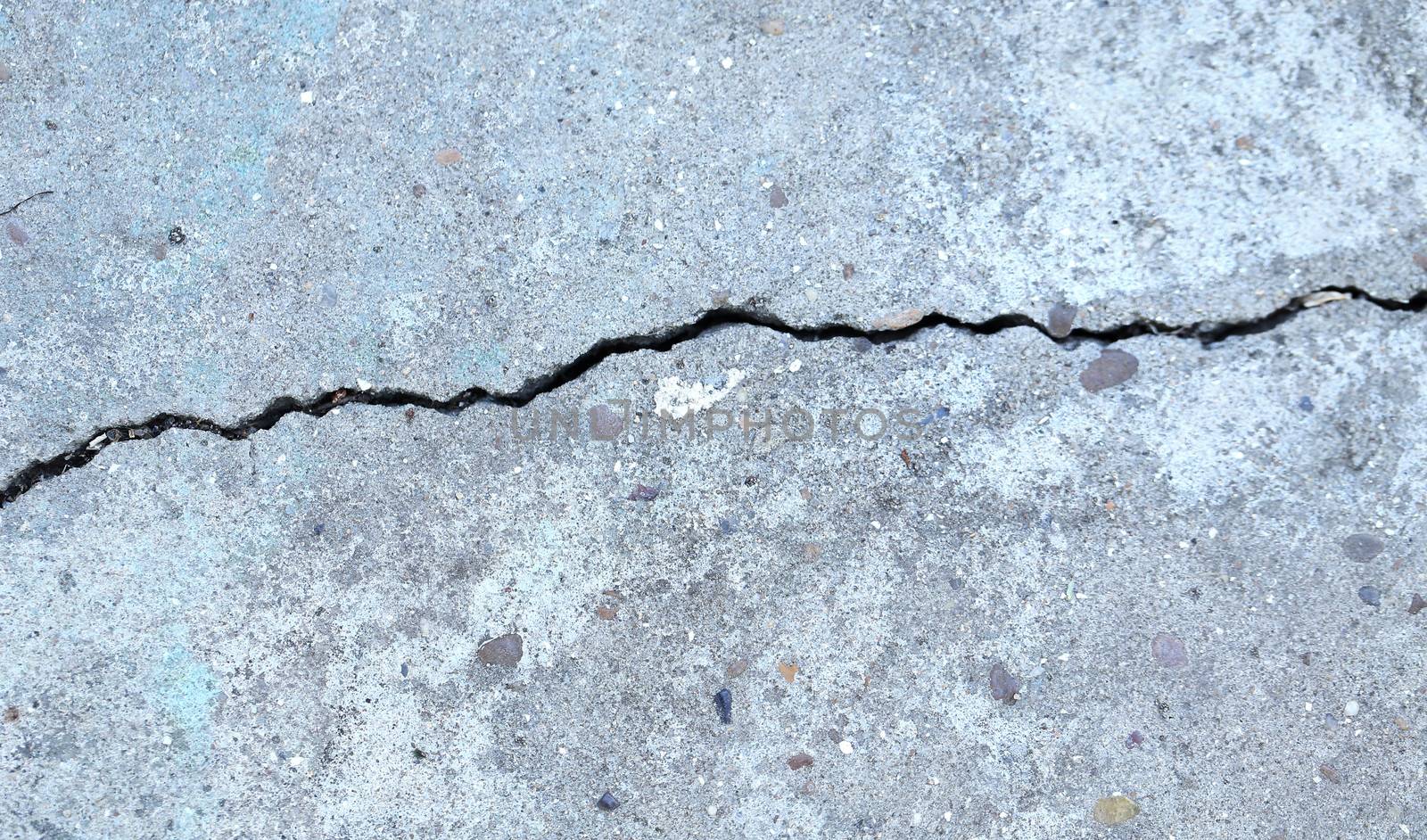 Fissure on the gray concrete wall. Cloth up.