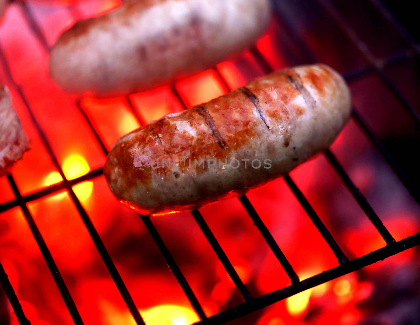 Juicy grilled sausages on a flaming grill. Close up.