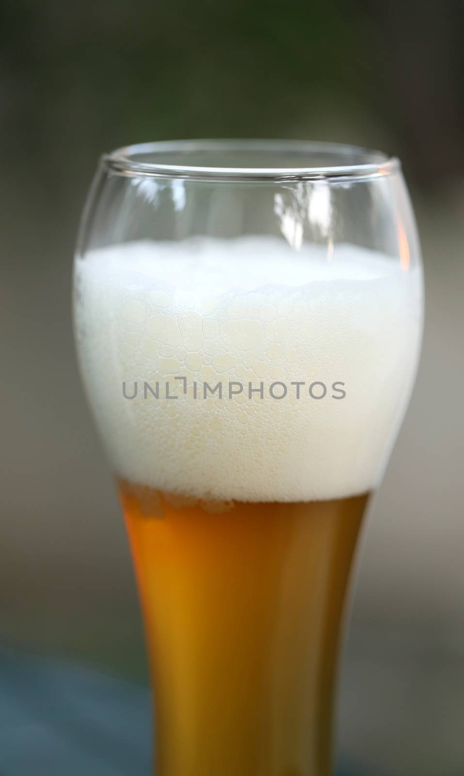 Glass of Bear with foam. Blurred background.