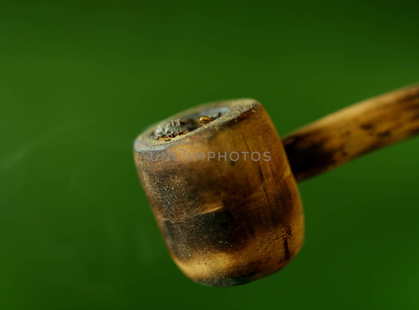 Simple tobacco pipe. Isolated on a green background.