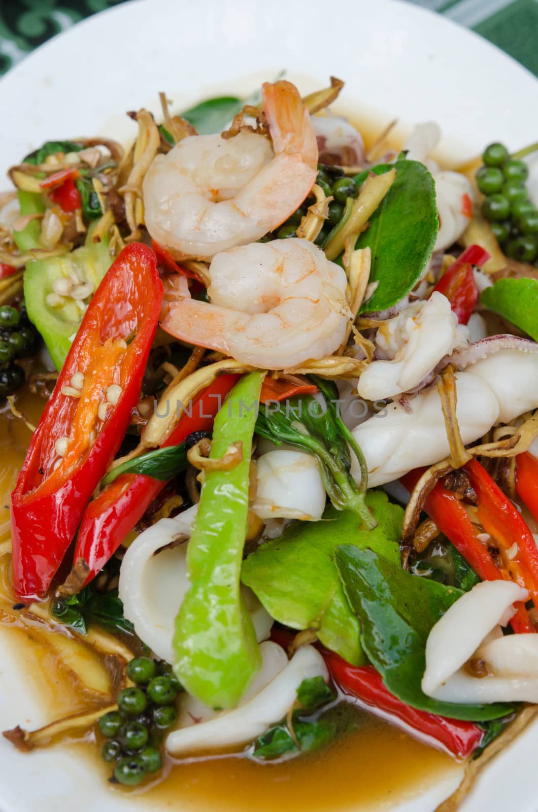 top view  fried  shrimp and squid with herbal vegetable on white dish