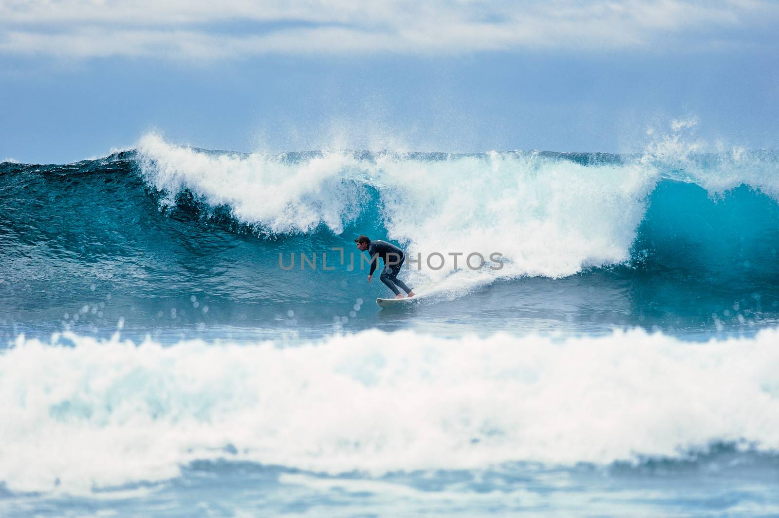 Surf on a large blue ocean wave