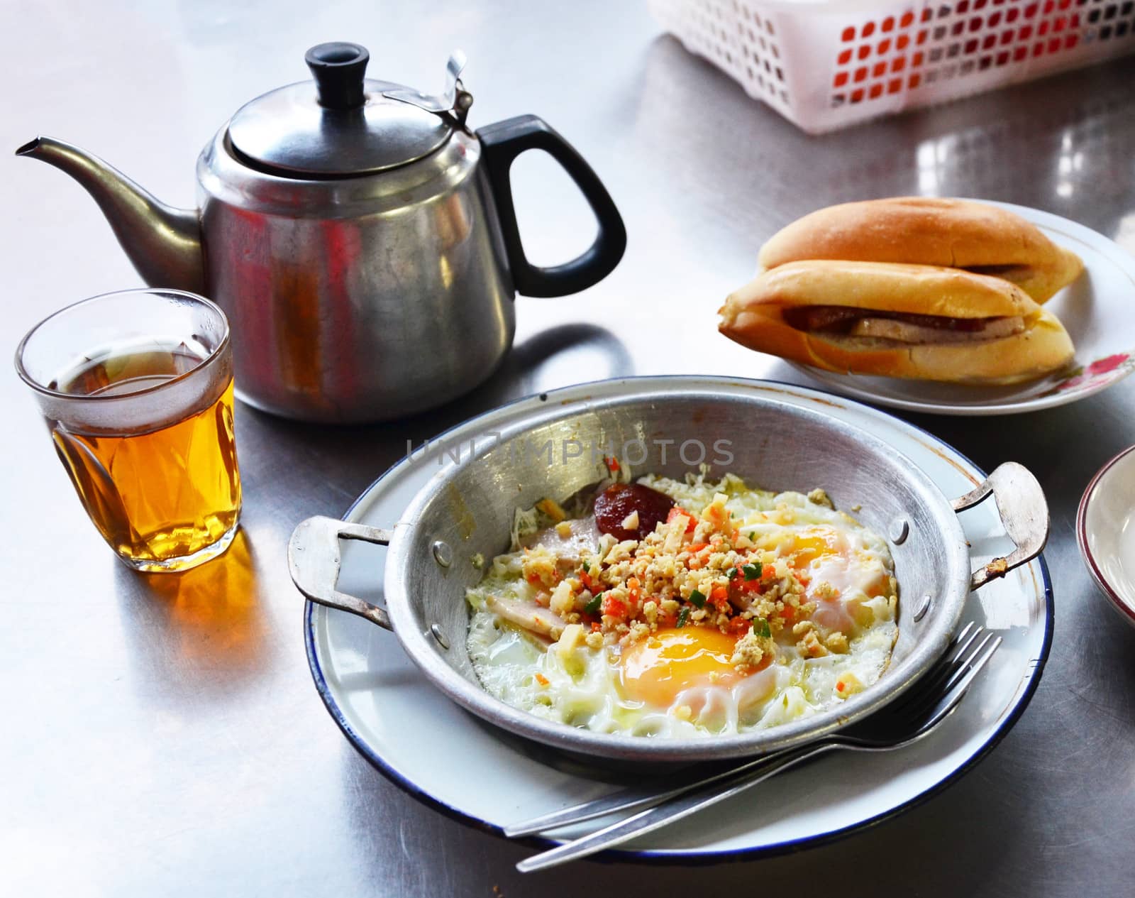 Fried egg with pork and sausage in hot pan, Breakfast in Thai style