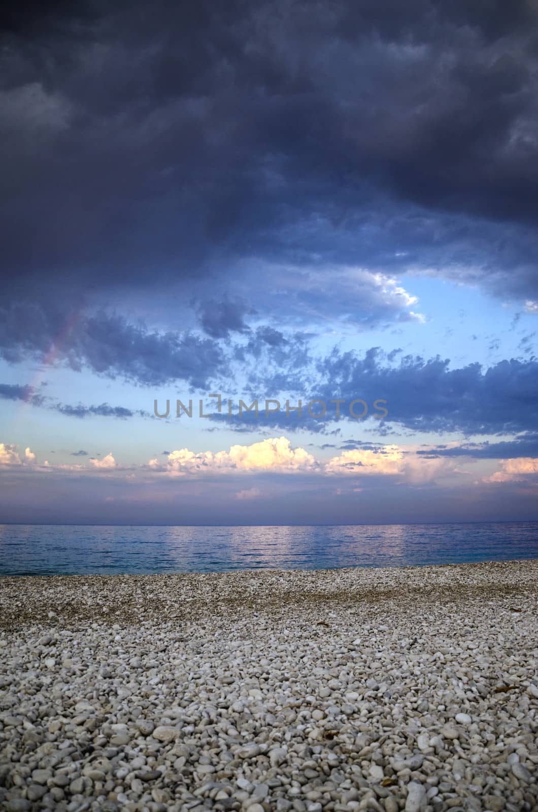 View from beach on a changing weather with rainbow.