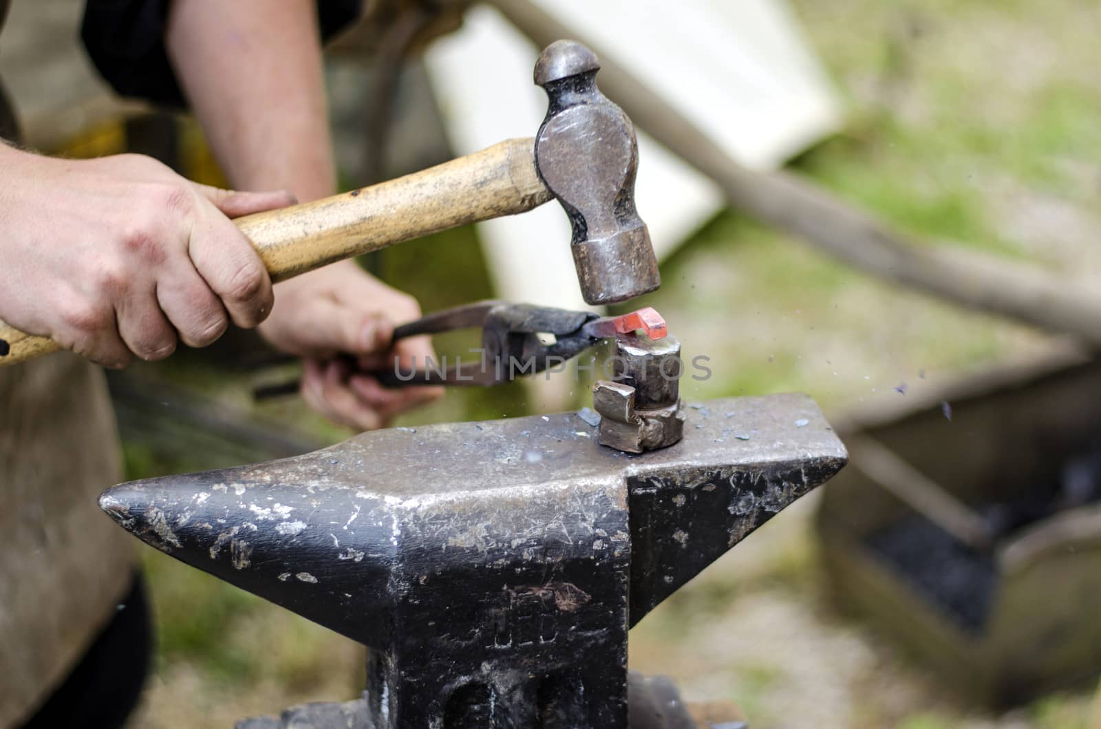 Blacksmith hammering an iron by Anzemulec