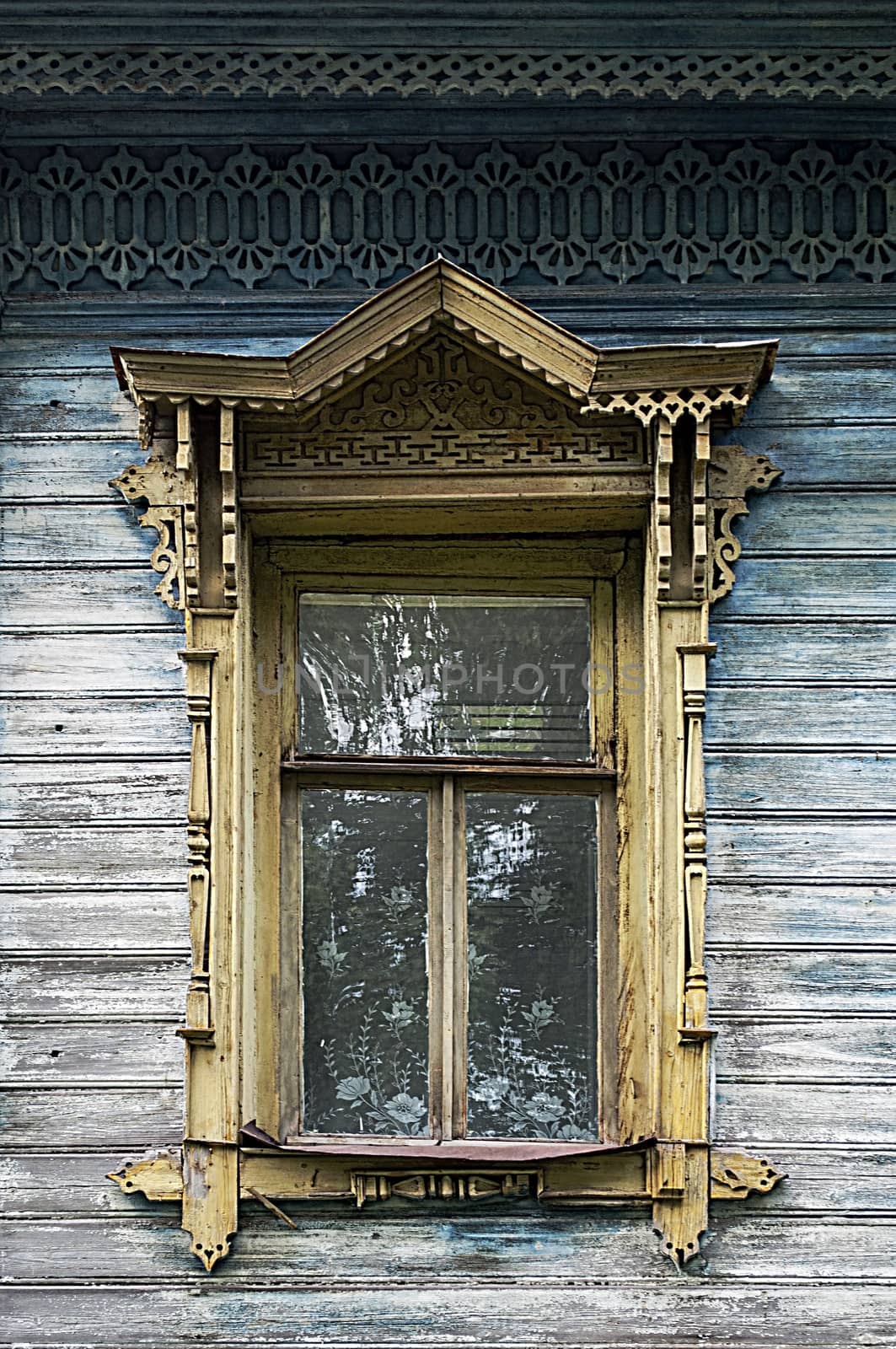 Old wooden window with carved platbands, Tutaev, Russia