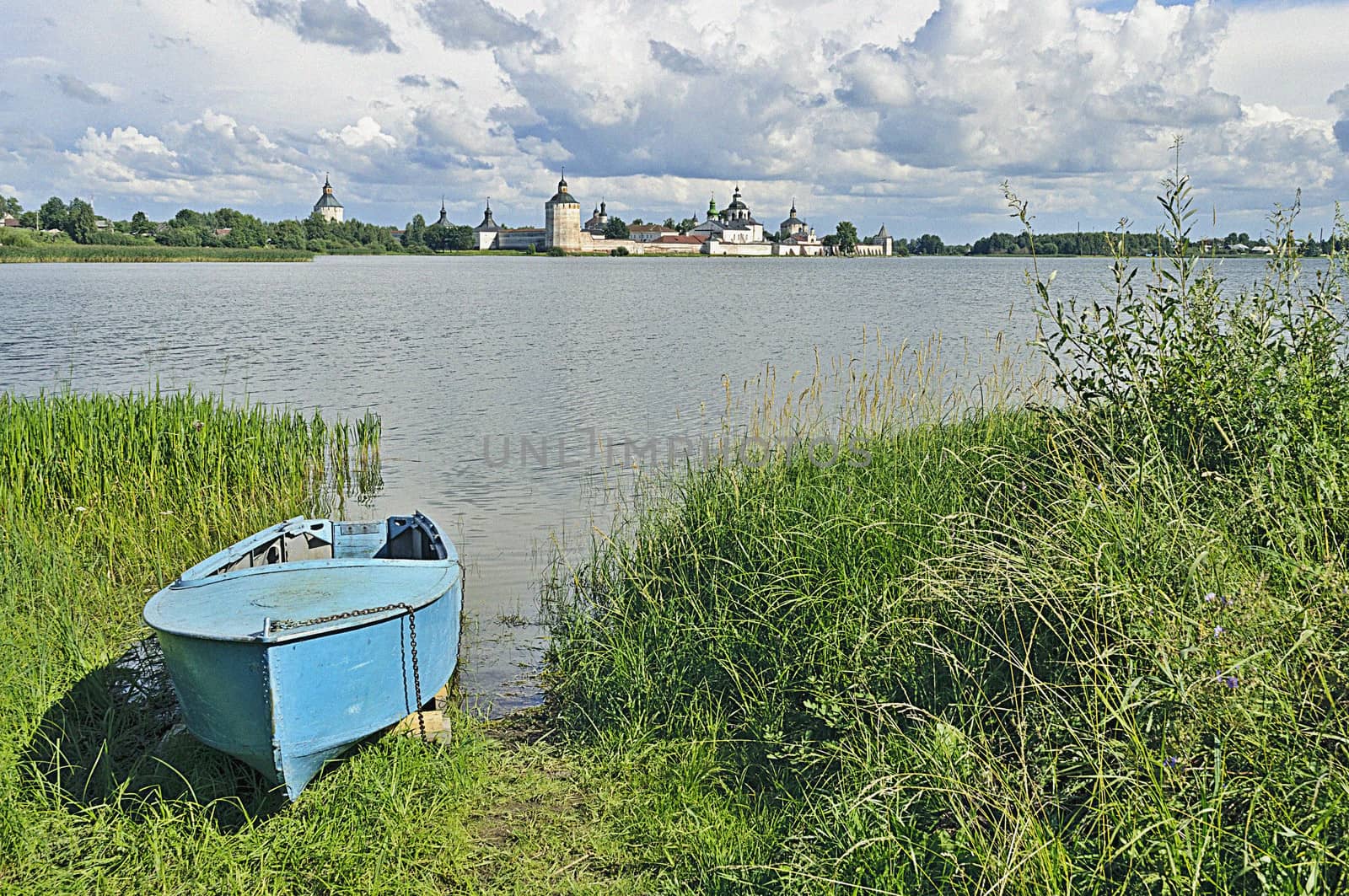 Metal boat on the shore of Lake Siverskoye. On the opposite bank - ancient Kirillo-Belozersky Monastery