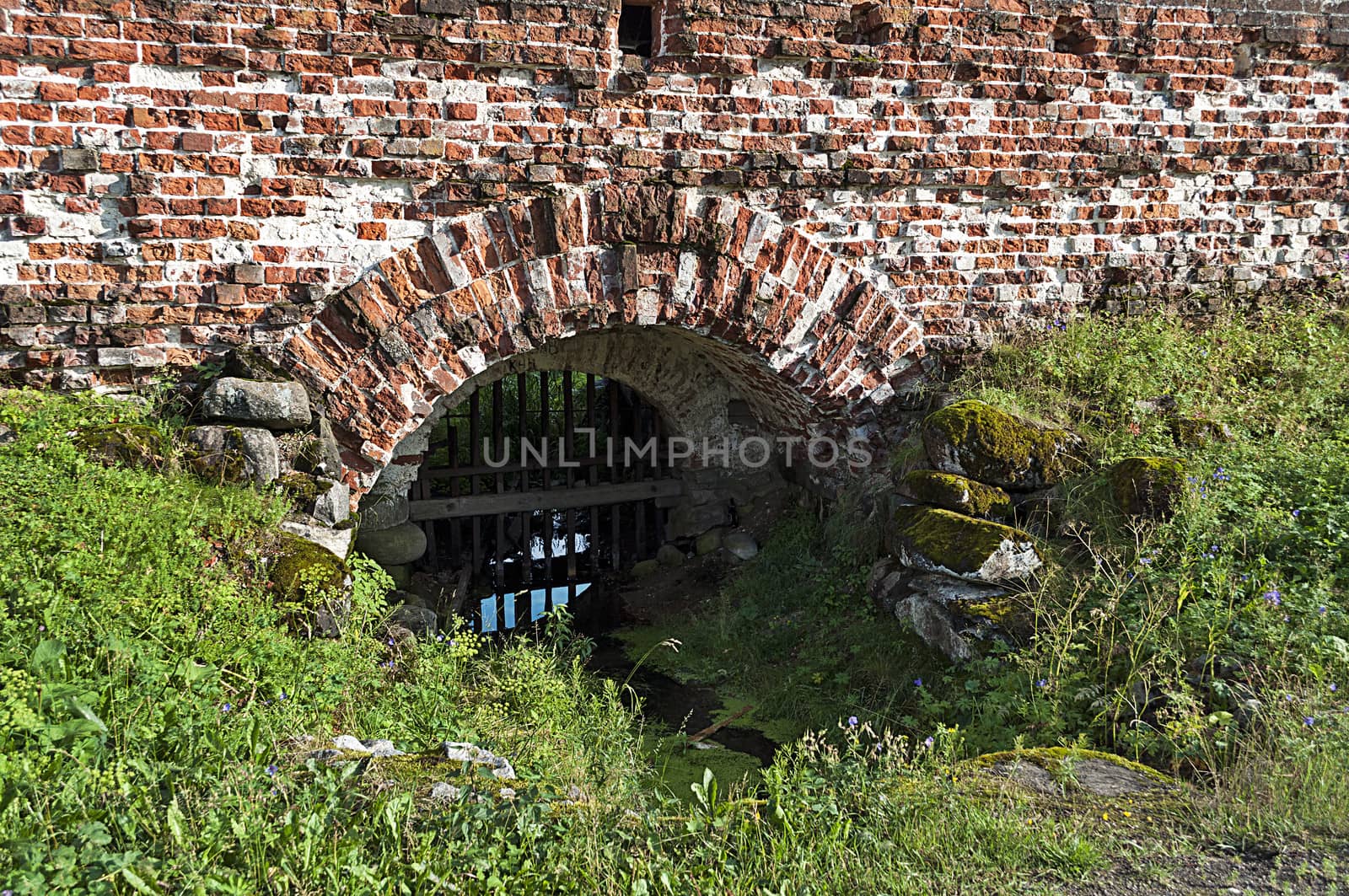 Brook flowing through the wall of an ancient russian Kirillo-Belozersky monastery