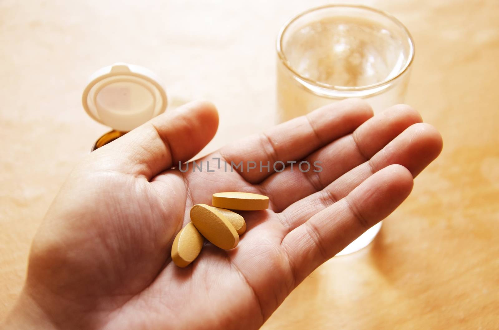 Pills spilling from a bottle into a hand.