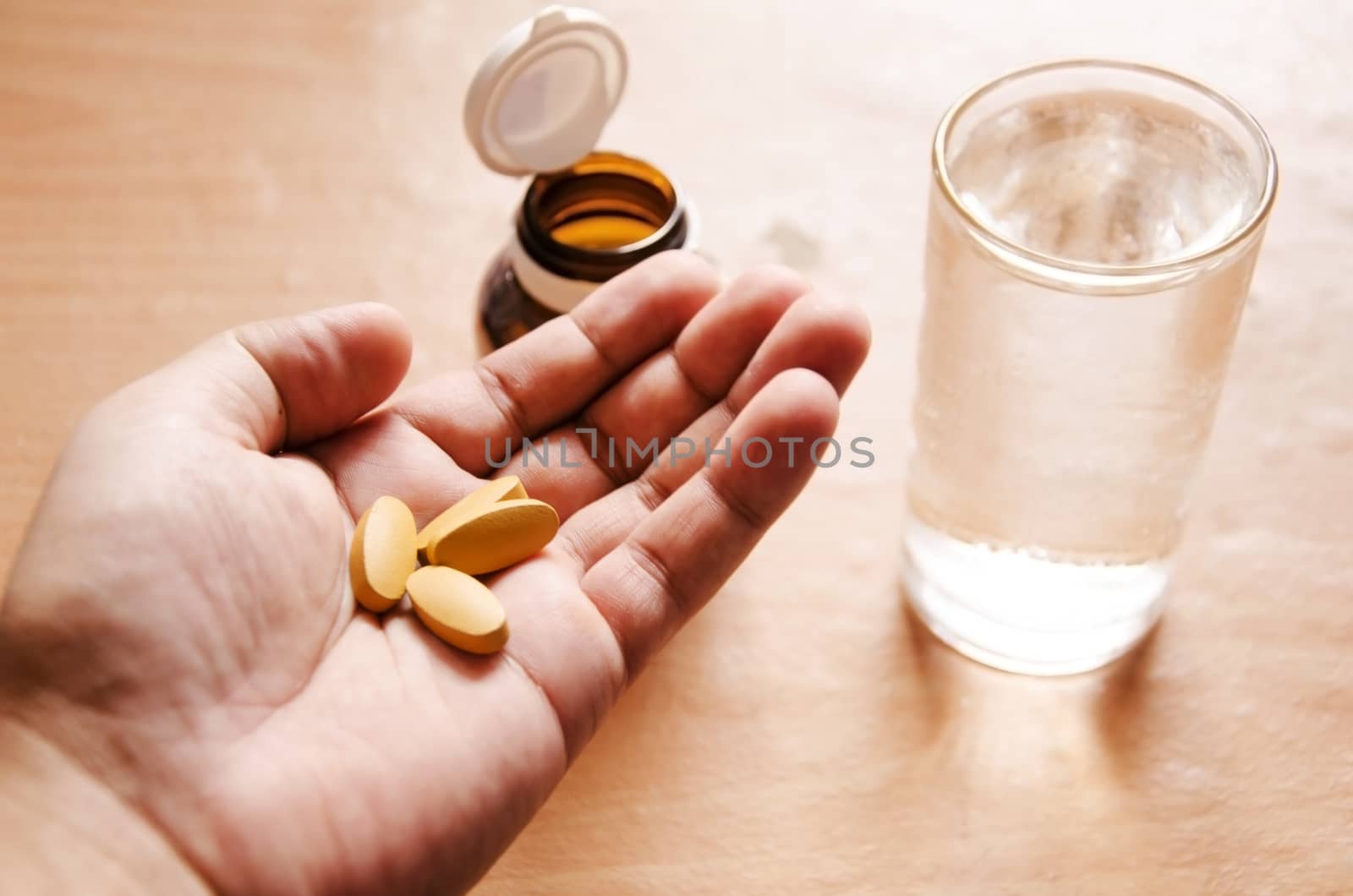 Pills spilling from a bottle into a hand.