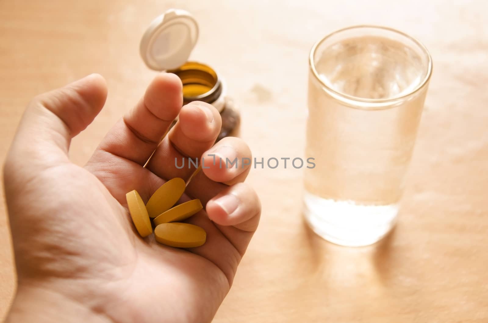Hand holding yellow pills