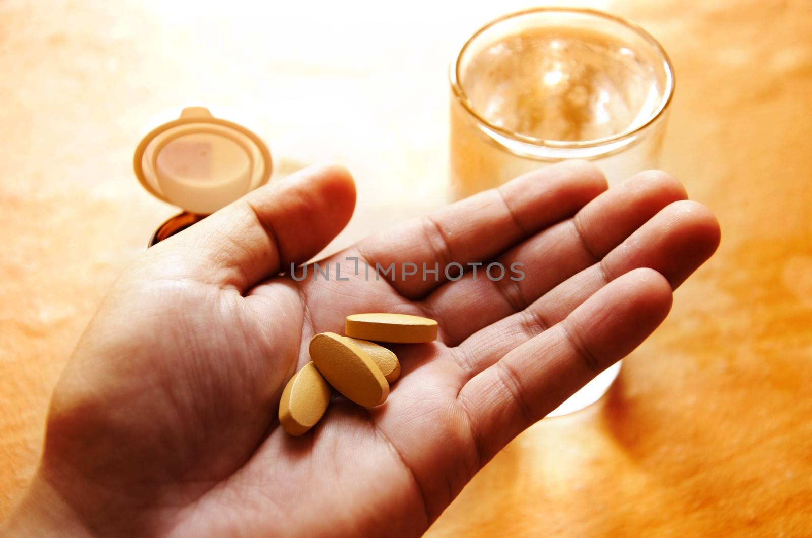 Pills spilling from a bottle into a hand.
