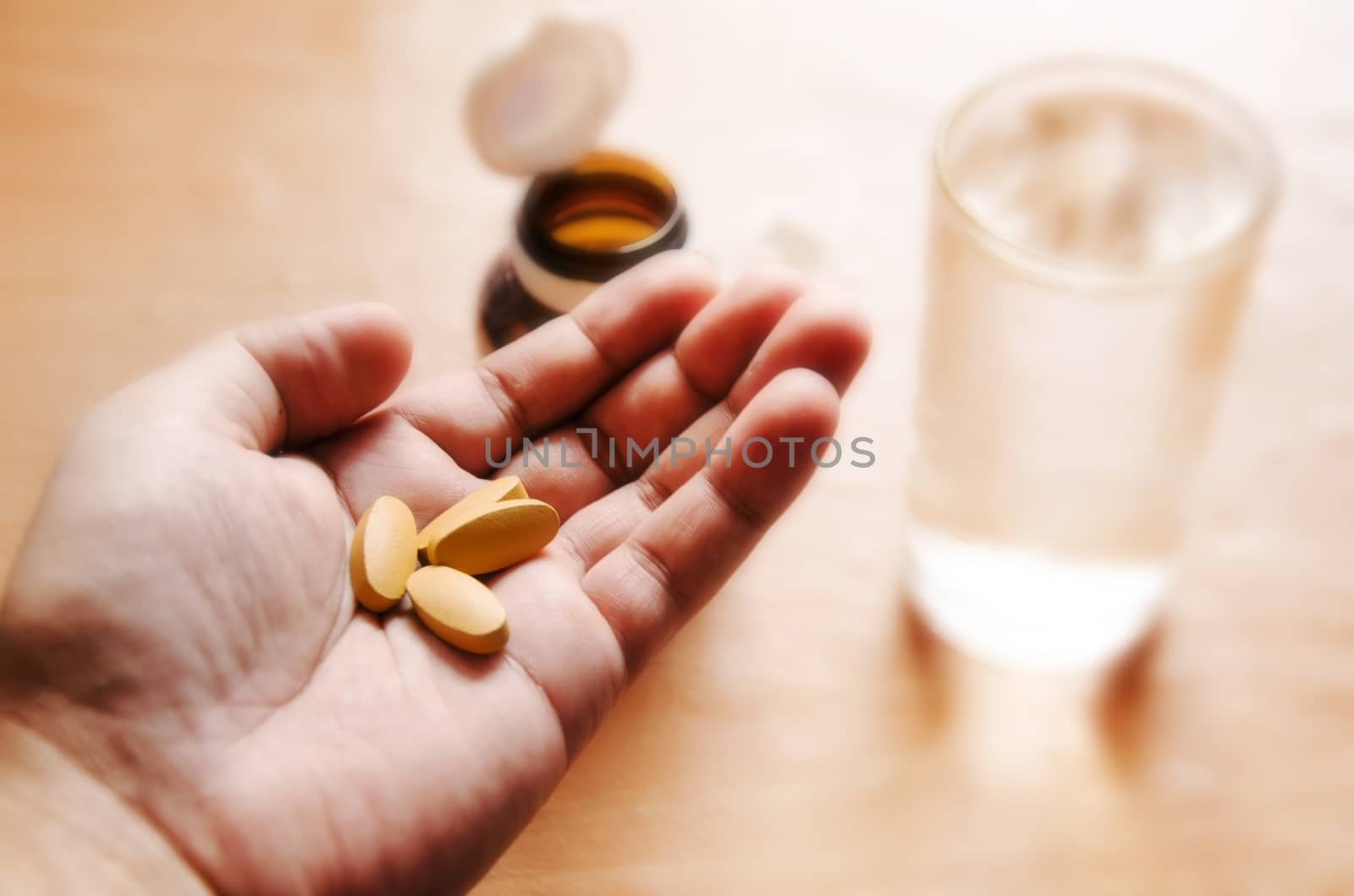 Pills spilling from a bottle into a hand.