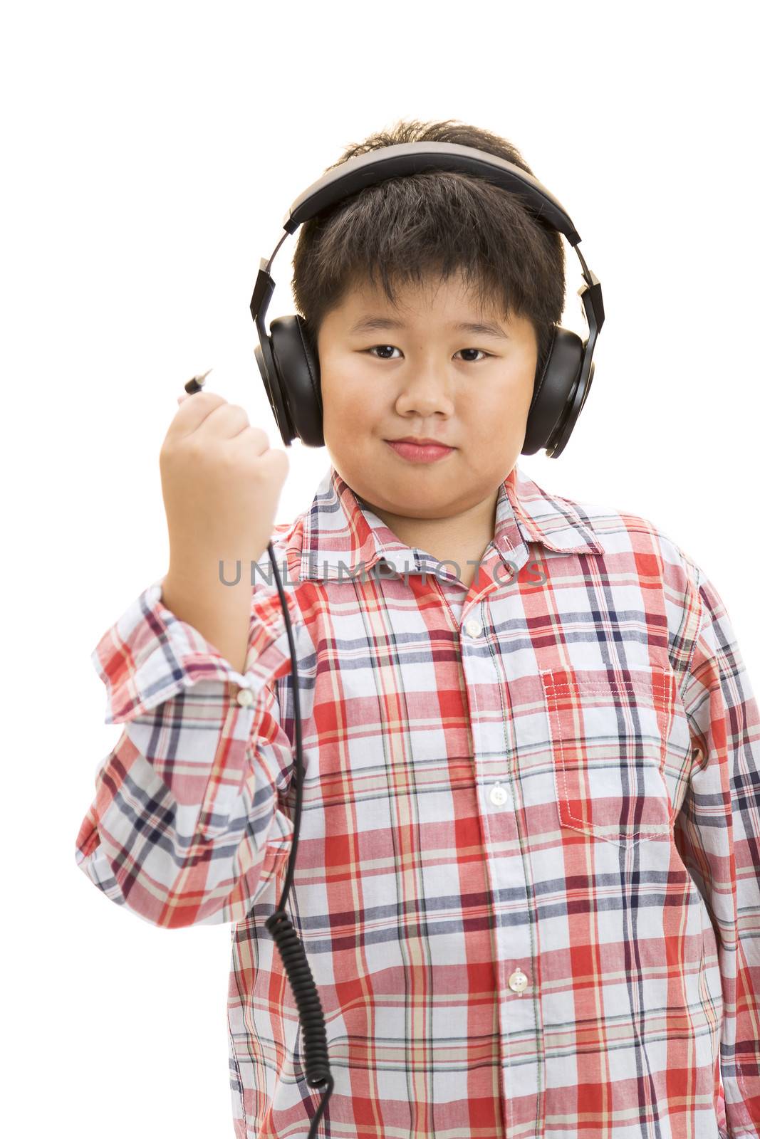 A smiling boy unplug his headphone on isolated background.