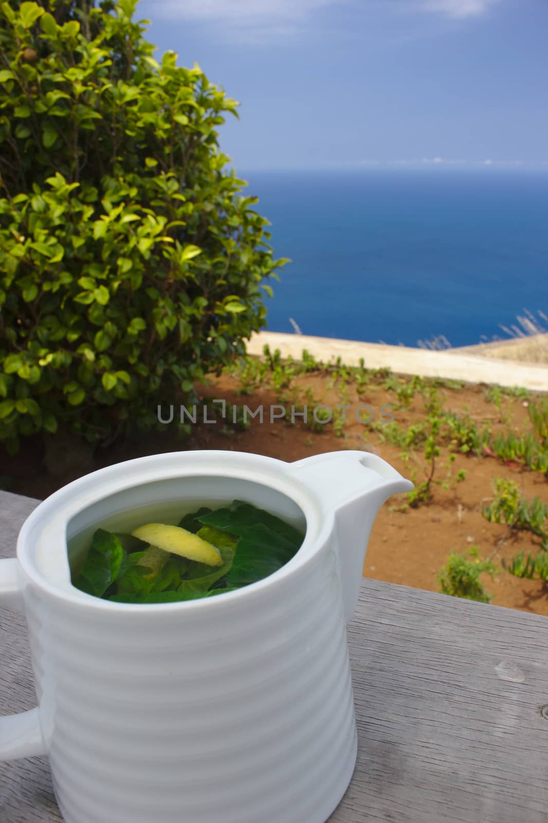 A pot of fresh leaves tea, made of peppermint leaves and lemon peel.