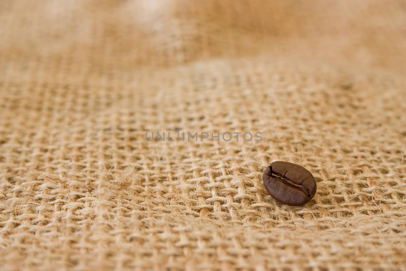 Coffee beans on burlap sack background