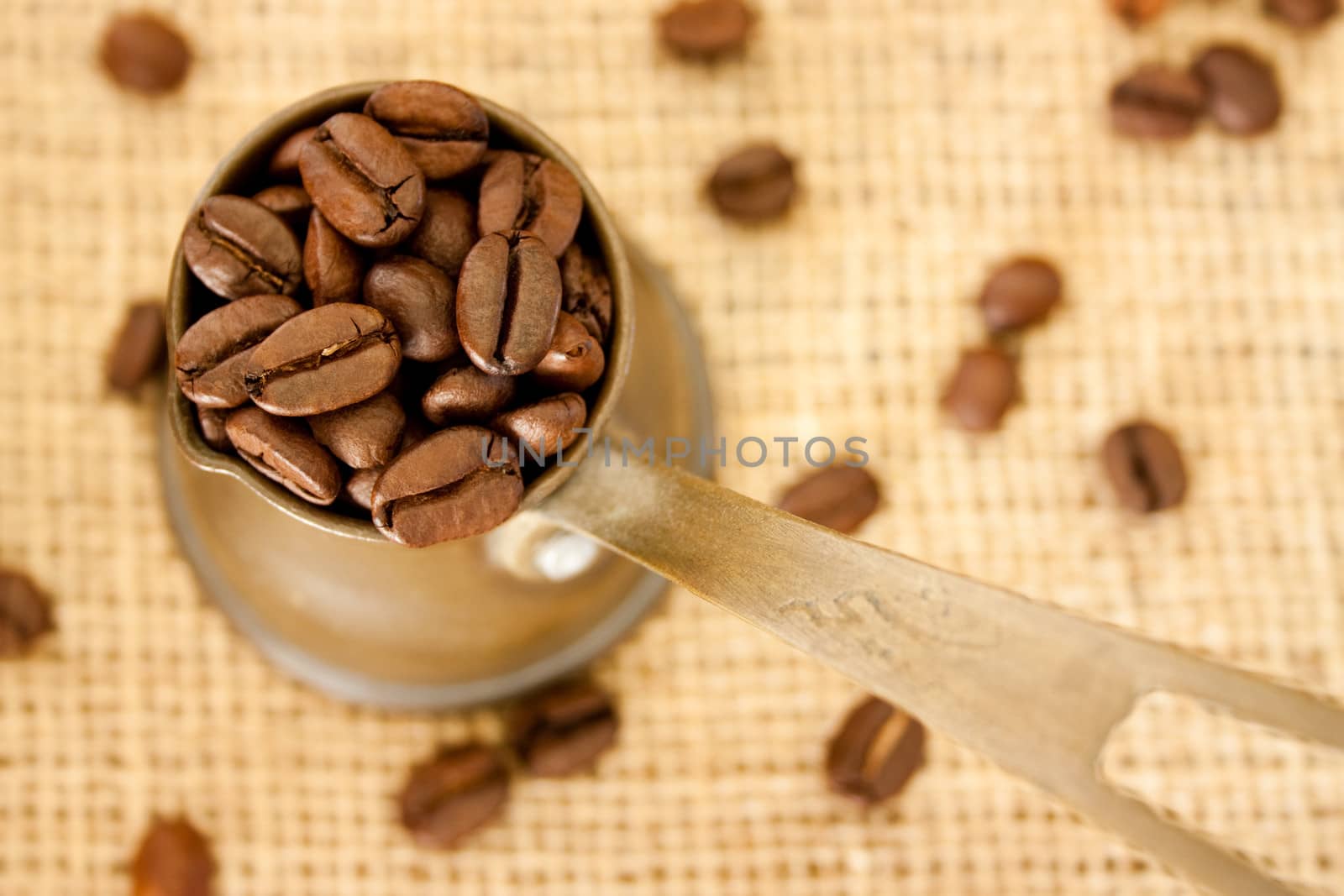 Coffee pot and coffee beans on burlap sack background