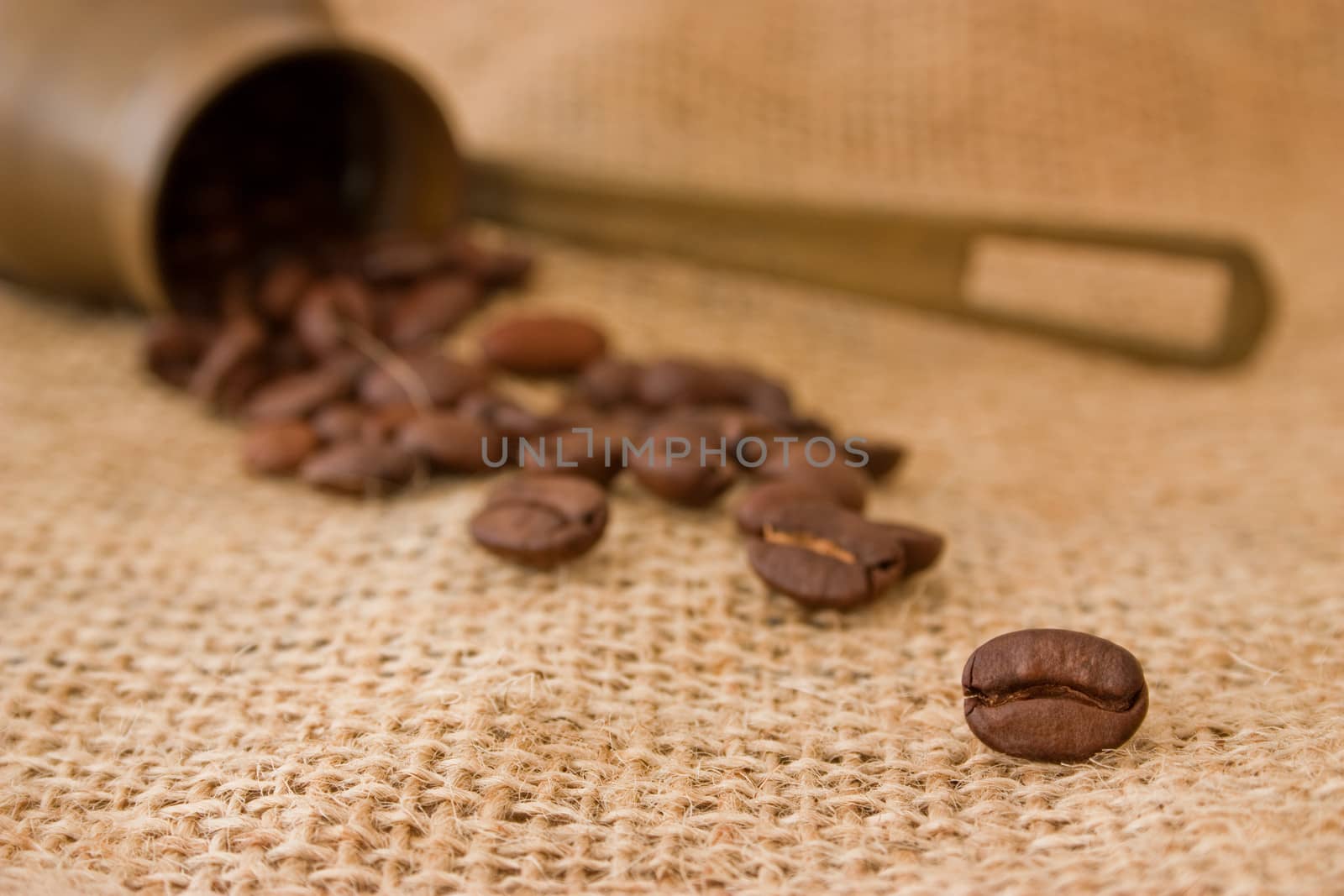 Coffee pot and coffee beans on burlap sack background