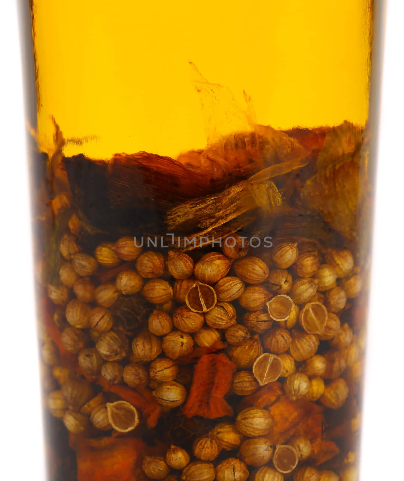 Oil with spicery into bottle. Close up.