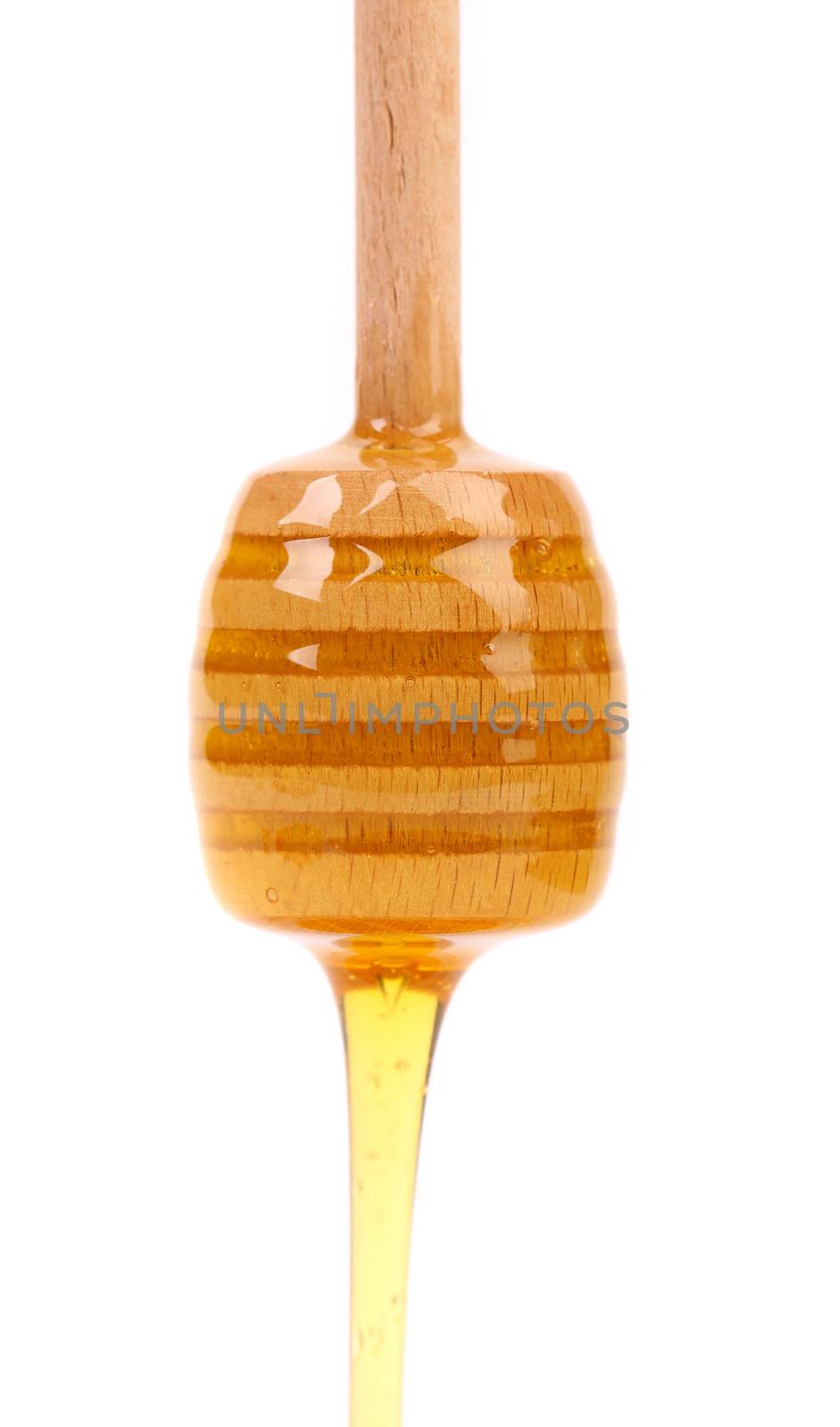 Honey dripping from a wooden honey dipper isolated on white background cutout