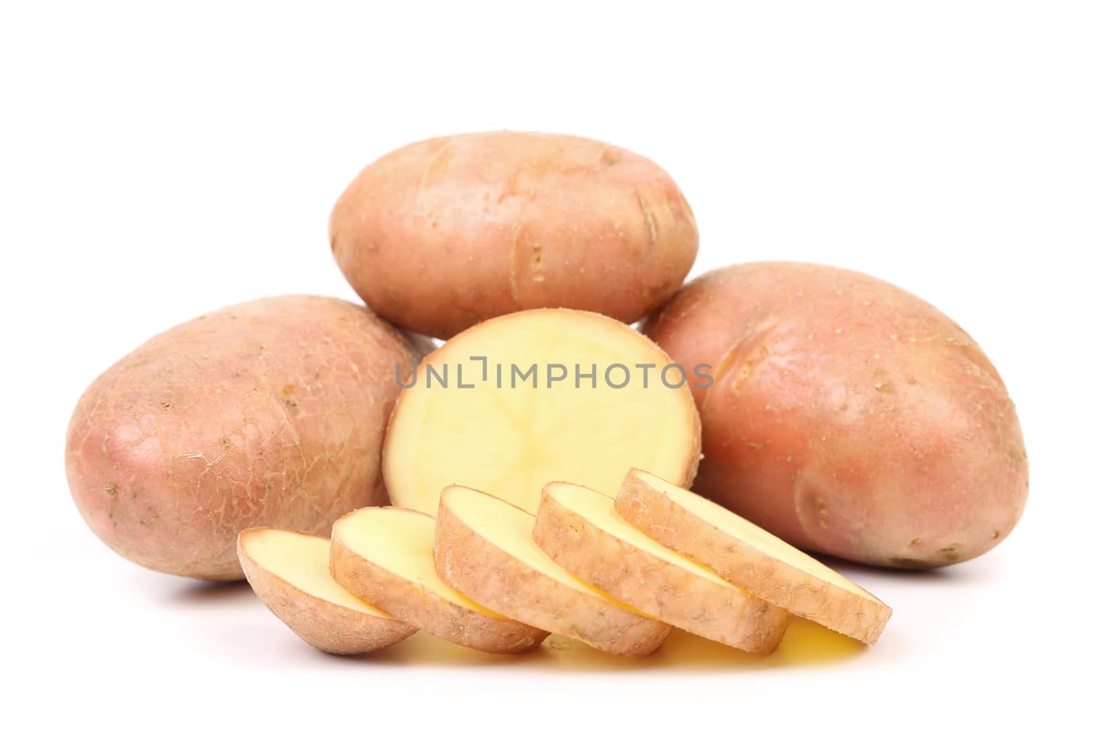 Ripe red potatoes and slices. White bacground.