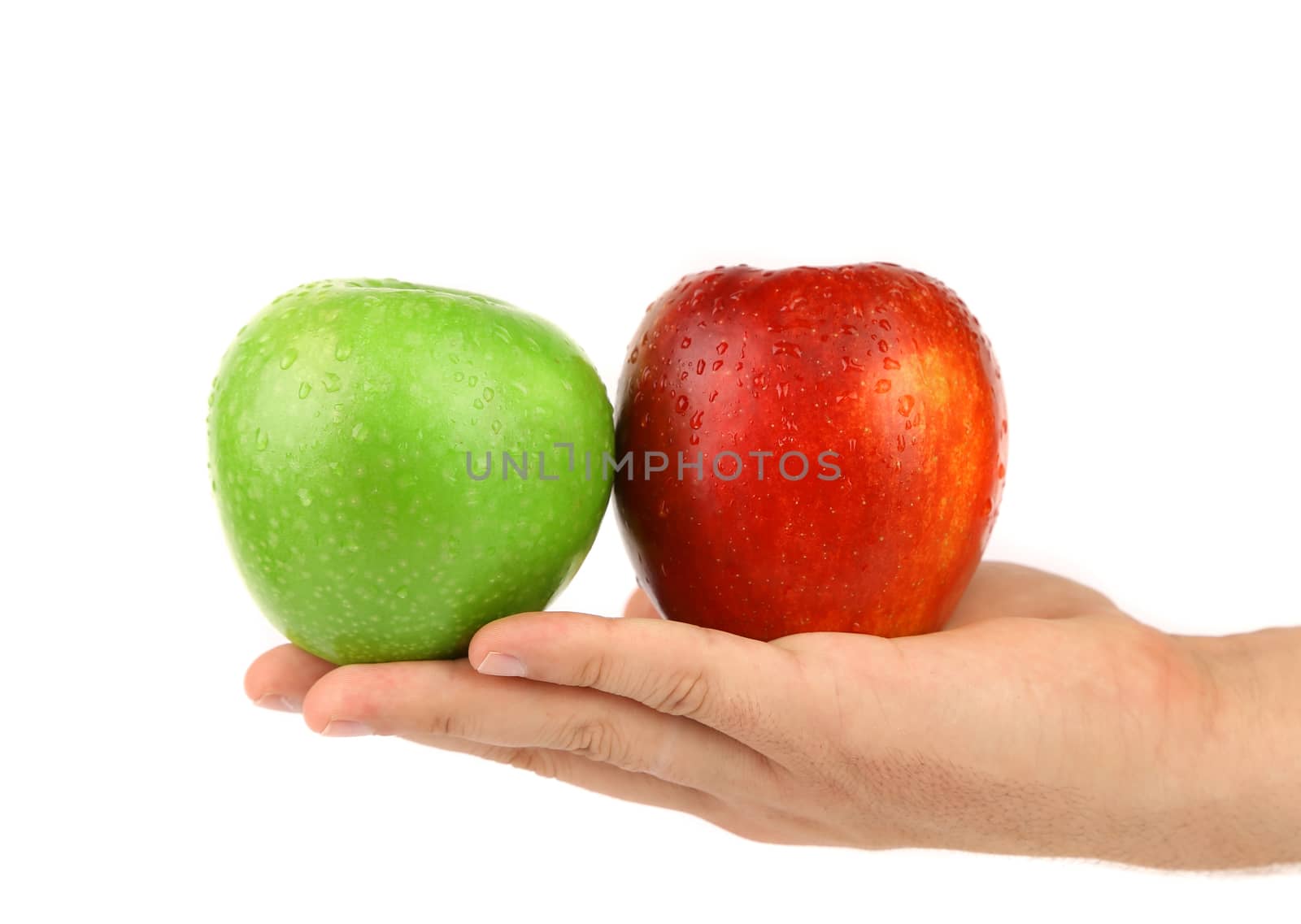 Hand holding green and red apples with water dropets