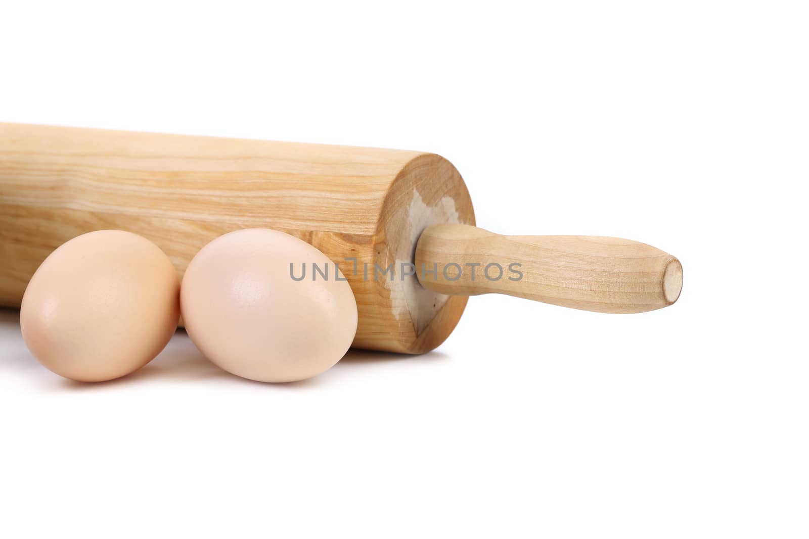 Wooden rolling pin with two chicken eggs