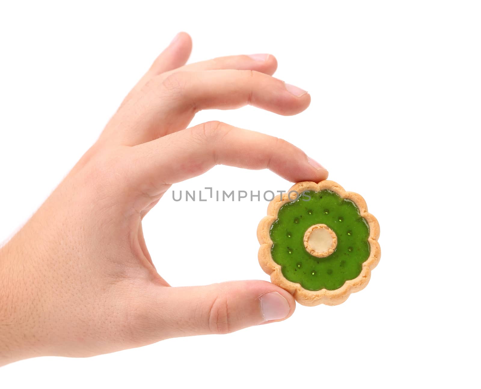 Hand holds biscuit with kiwi jam. White background.