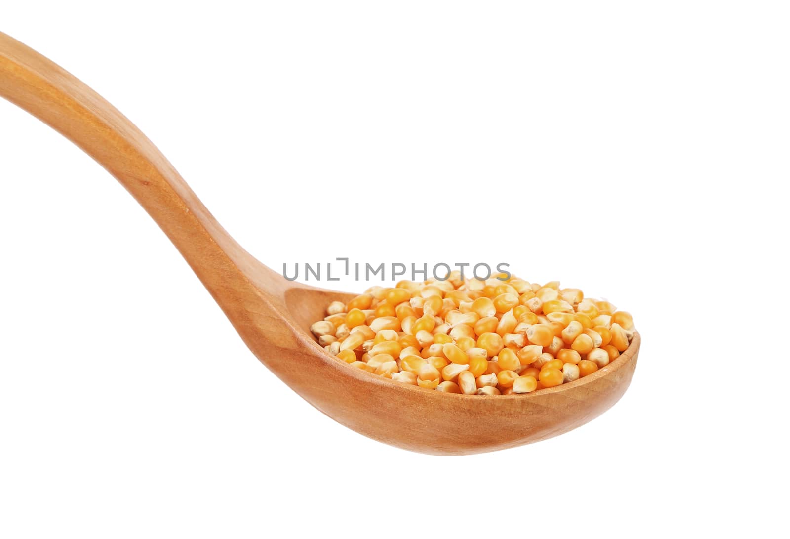 Corn grain into wooden spoon. Isolated on a white background.