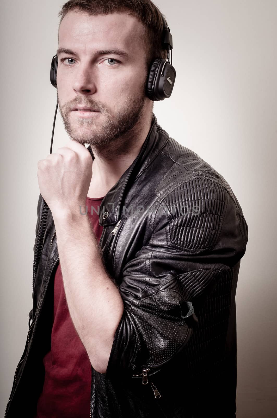 stylish hipster listening to music on gray background