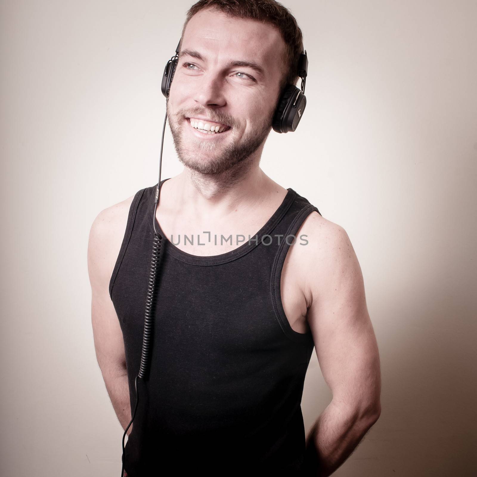 stylish hipster listening to music on gray background