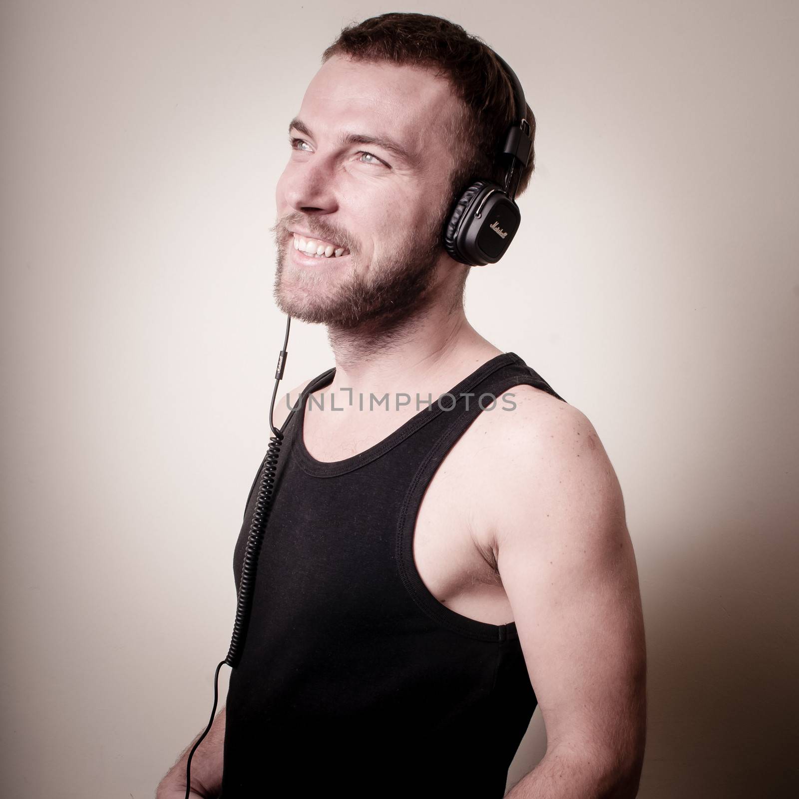 stylish hipster listening to music on gray background