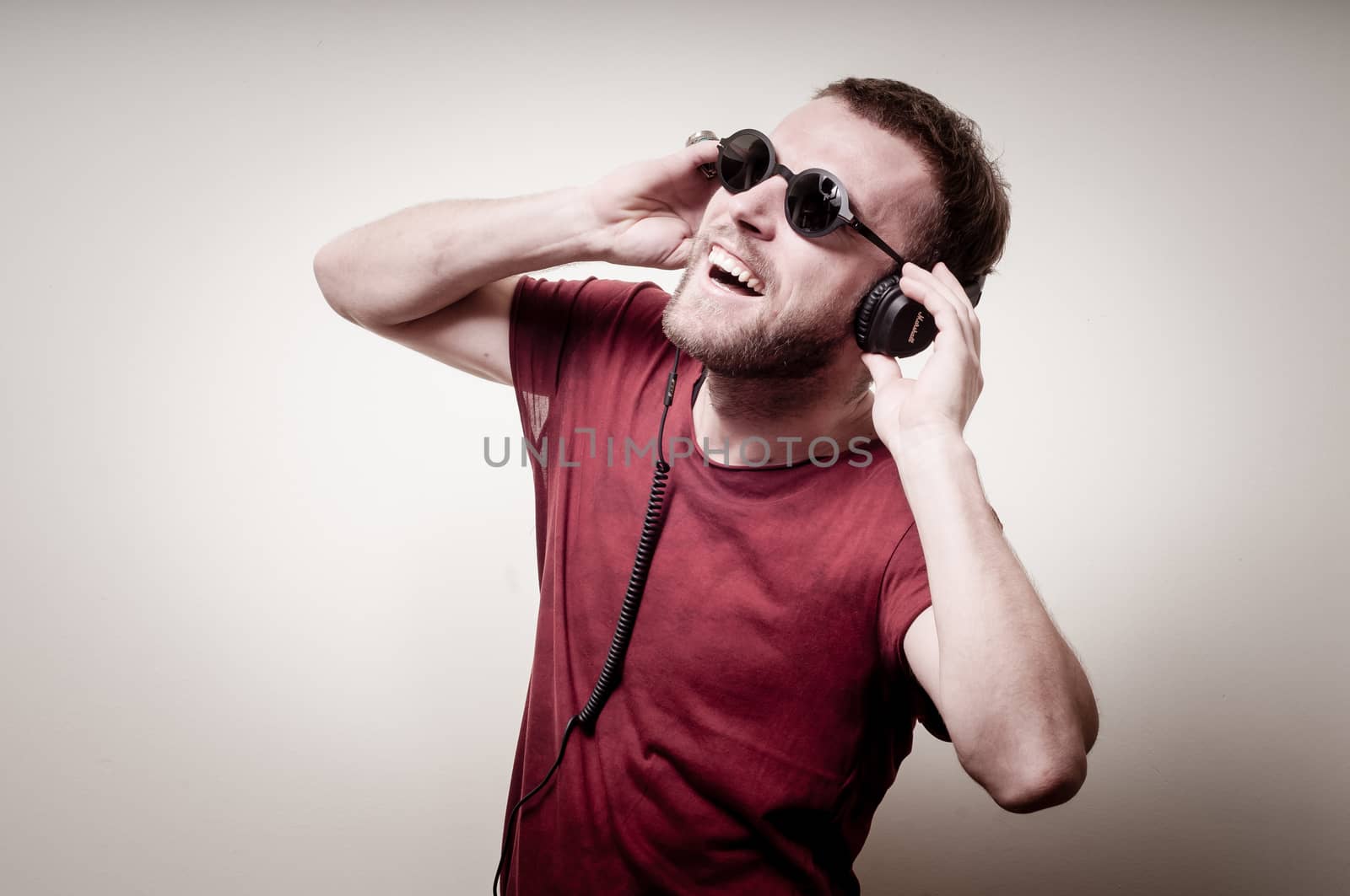 stylish hipster listening to music on gray background
