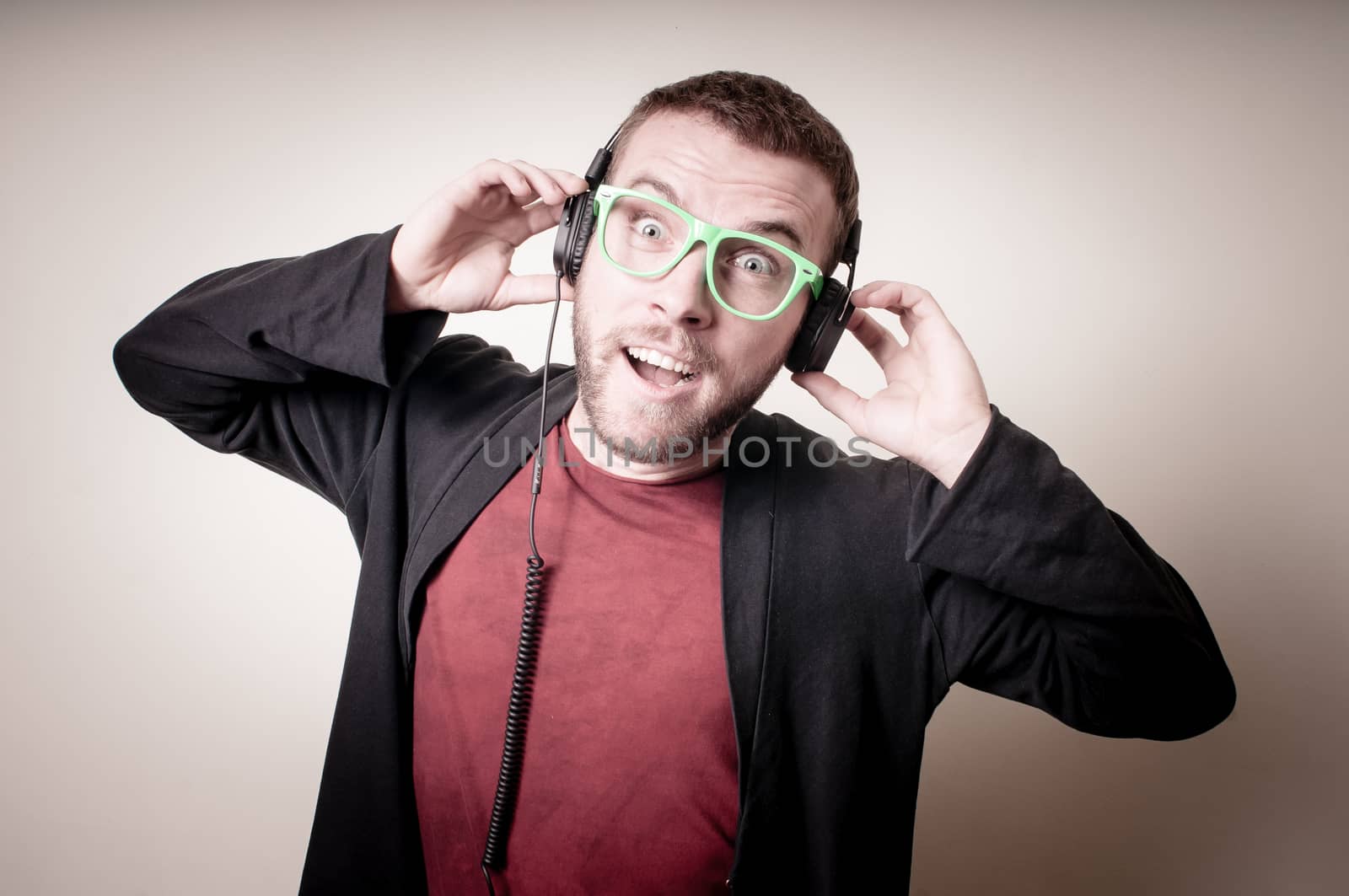 stylish hipster listening to music on gray background