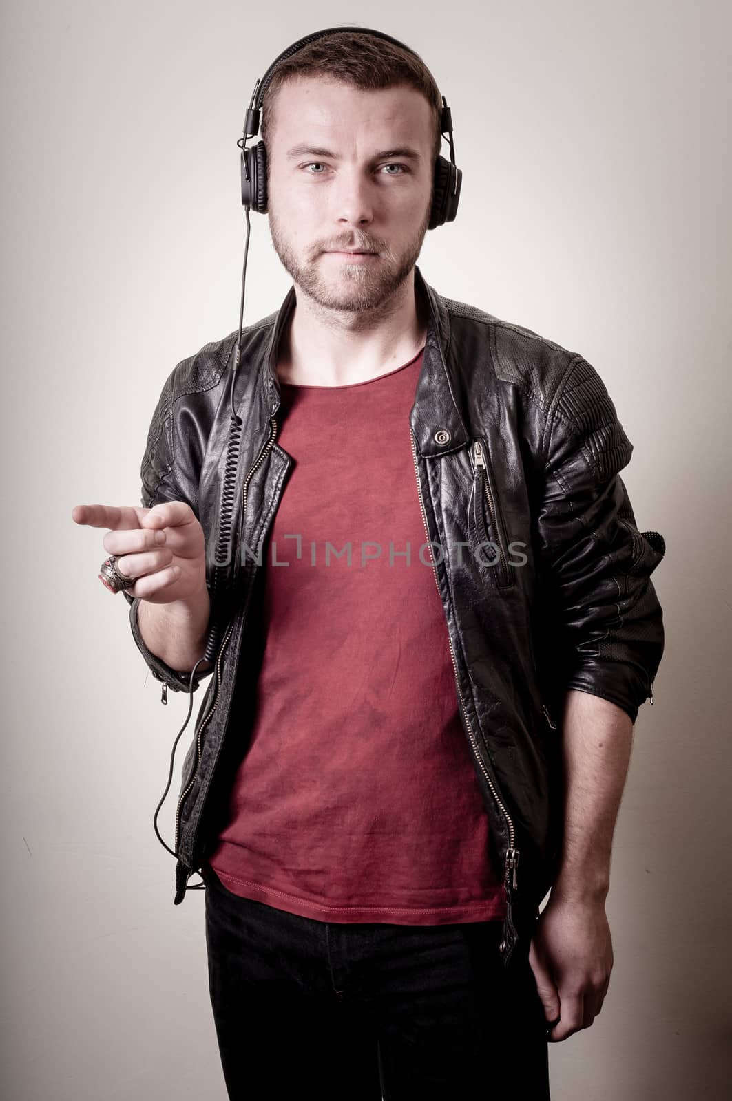 stylish hipster listening to music on gray background