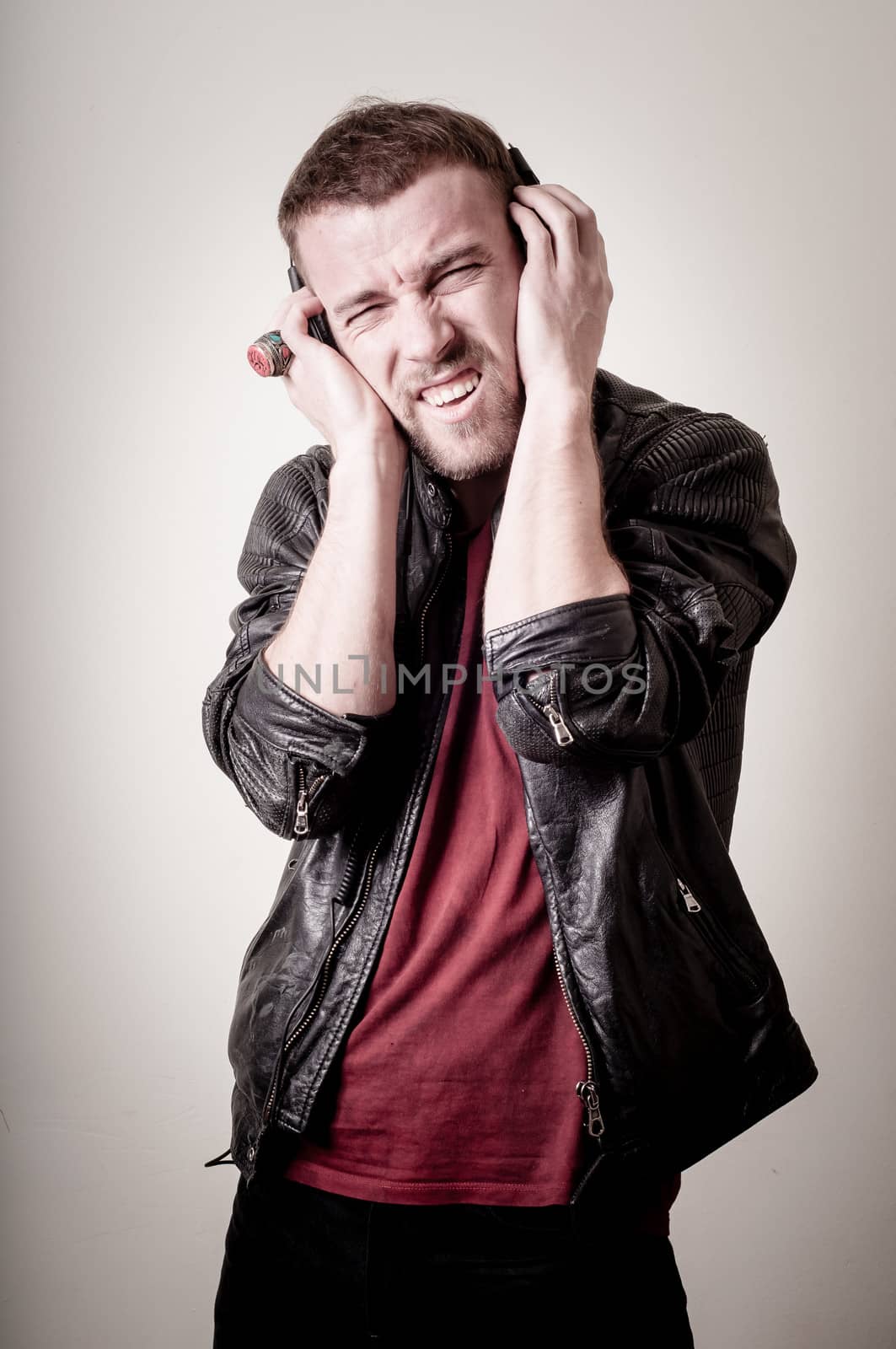 stylish hipster listening to music on gray background