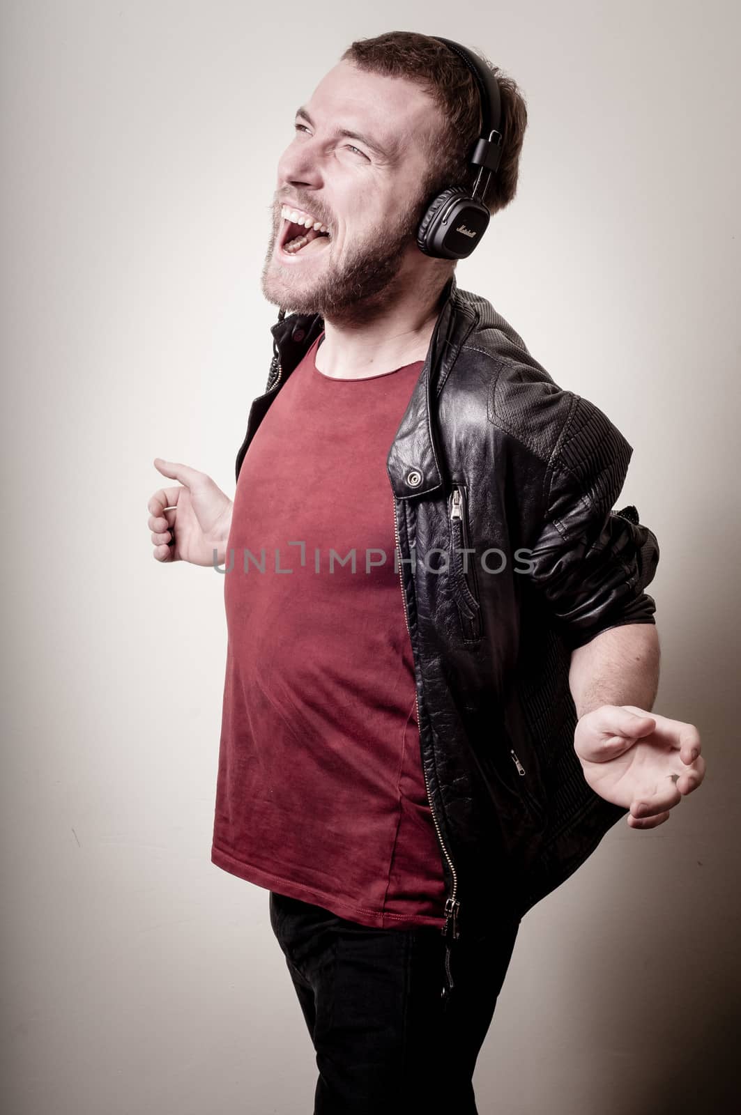 stylish hipster listening to music on gray background
