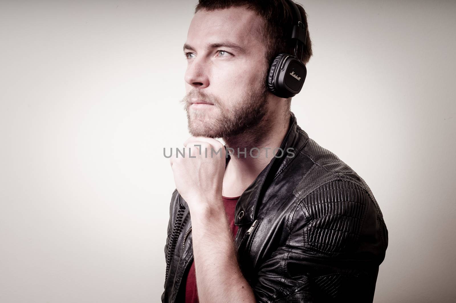 stylish hipster listening to music on gray background