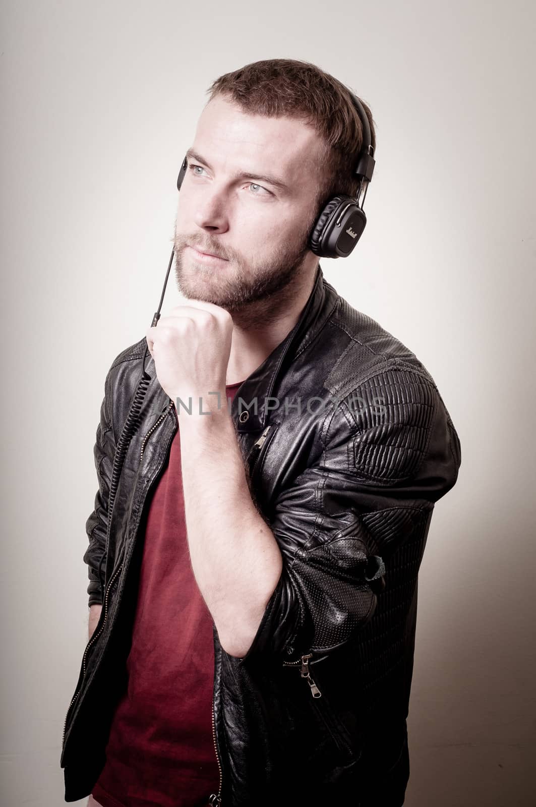 stylish hipster listening to music on gray background