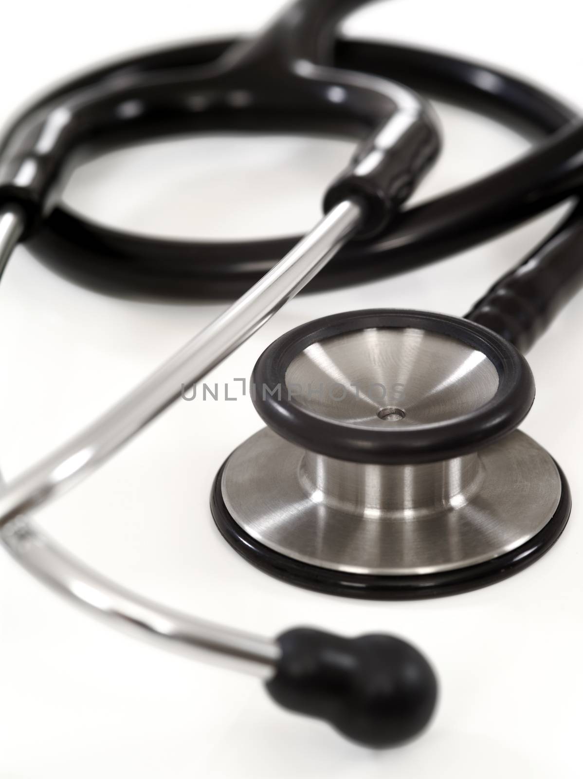 Macro cropped photo of a stethoscope on white background with slight shadow visible.