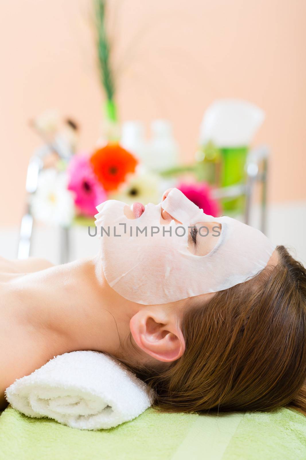 Wellness - woman receiving facial mask in spa for clean skin