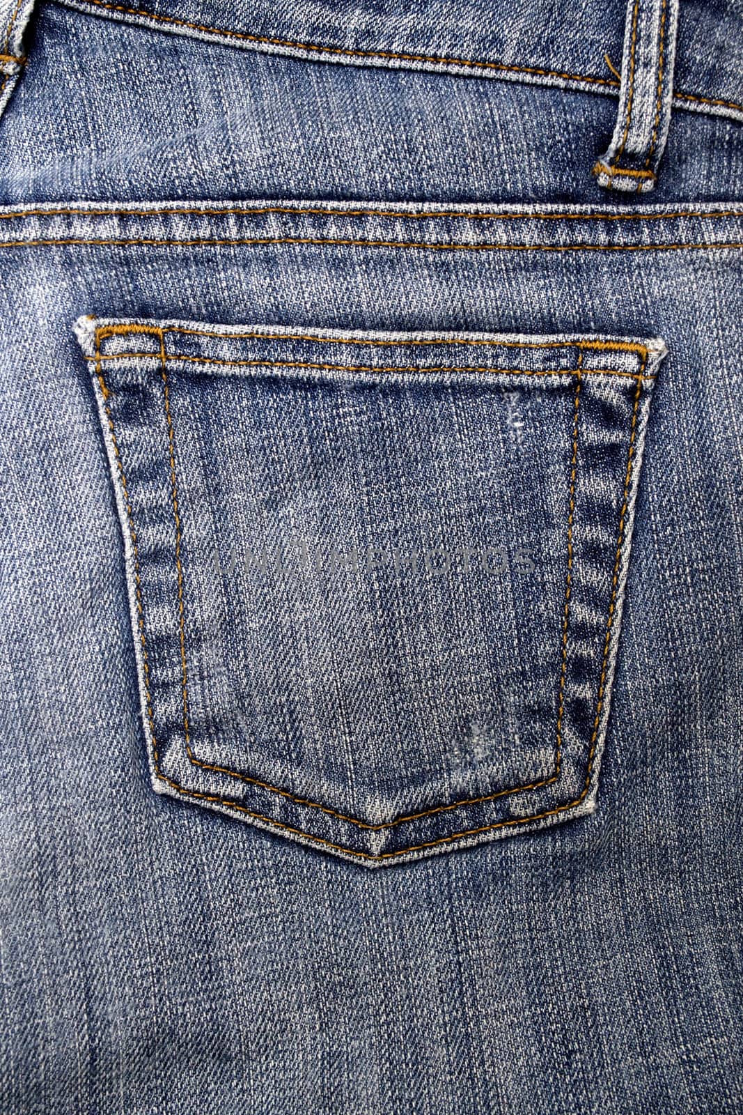 Close up image of denim jeans pocket with a ripped hole