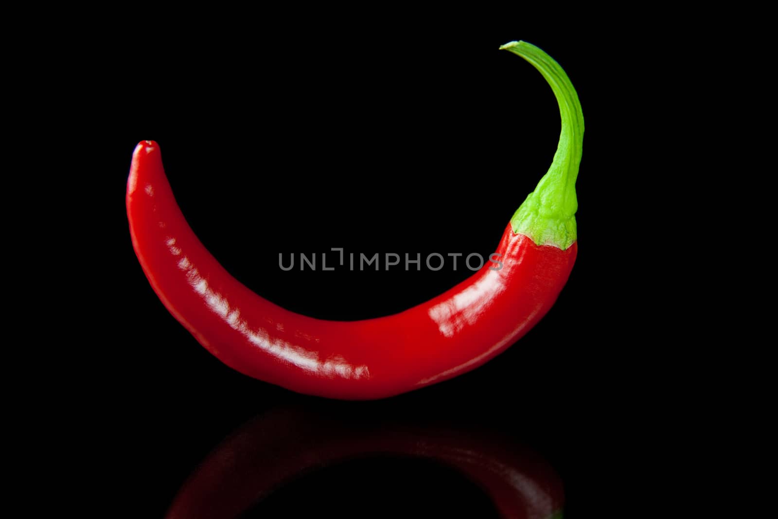 Red hot chili pepper on black background with reflection