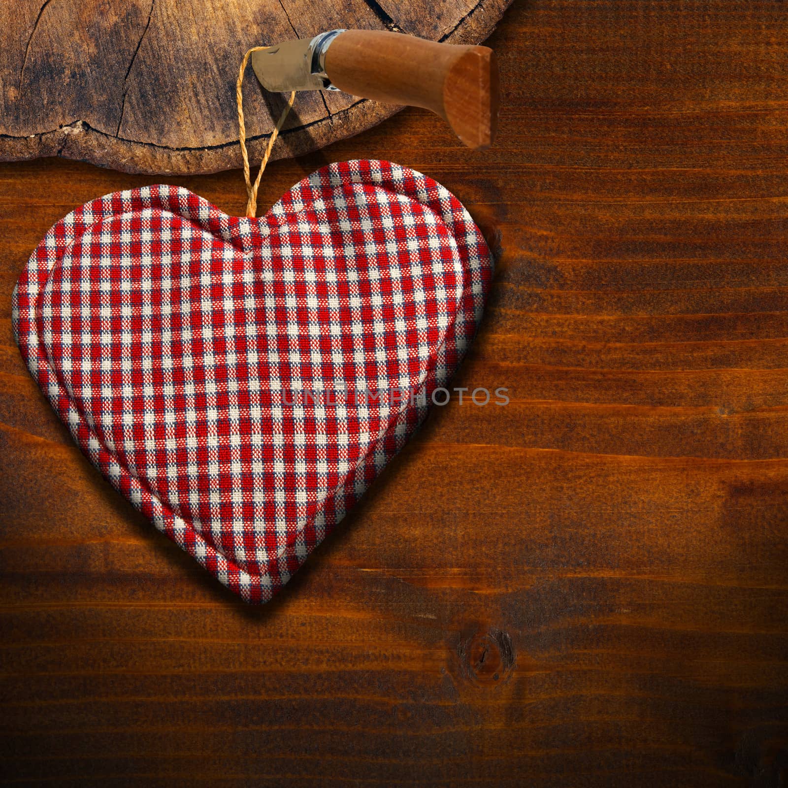 Handmade clothe heart hanging on wooden background with trunk section