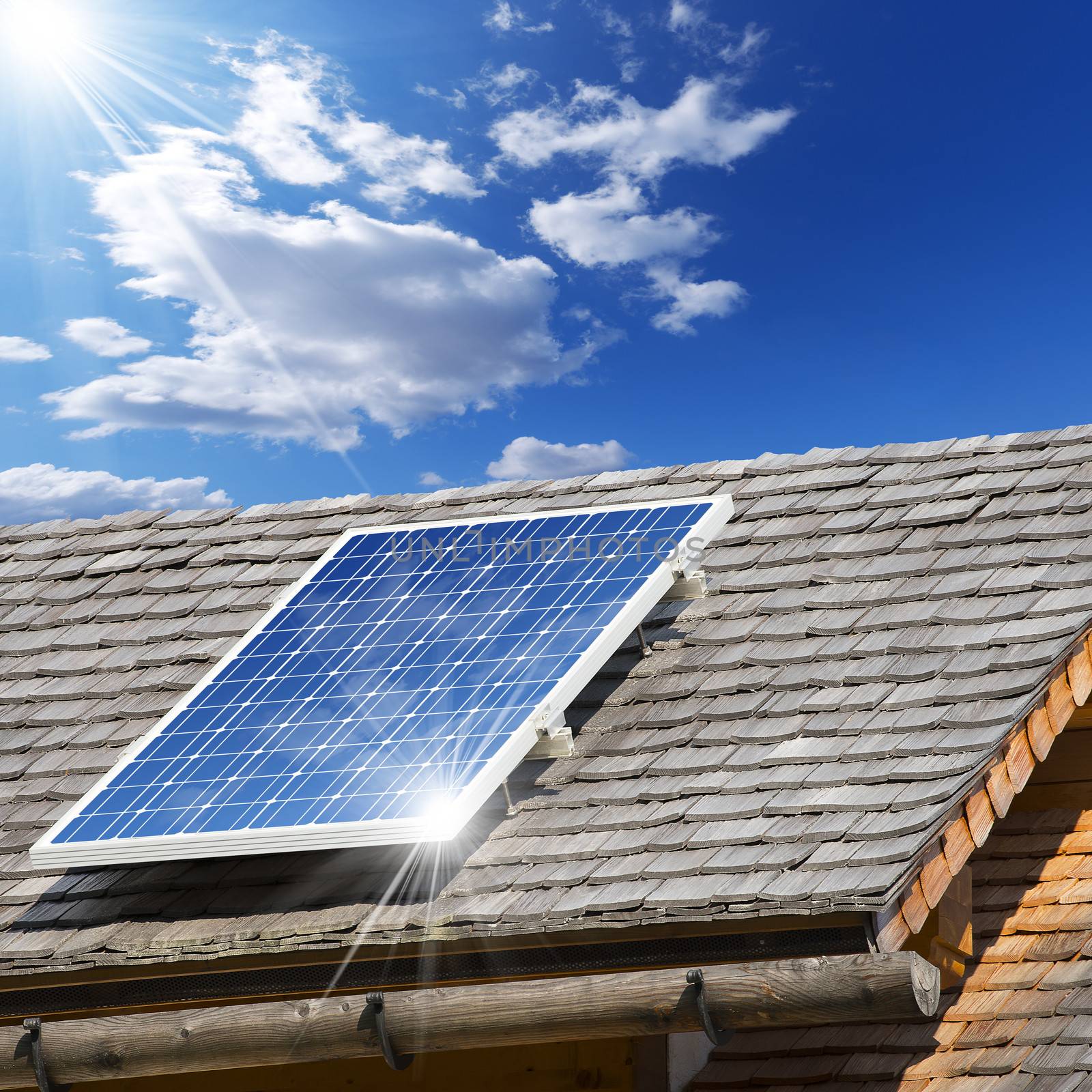 Old roof with wooden shingles and solar panel with reflection of blue sky