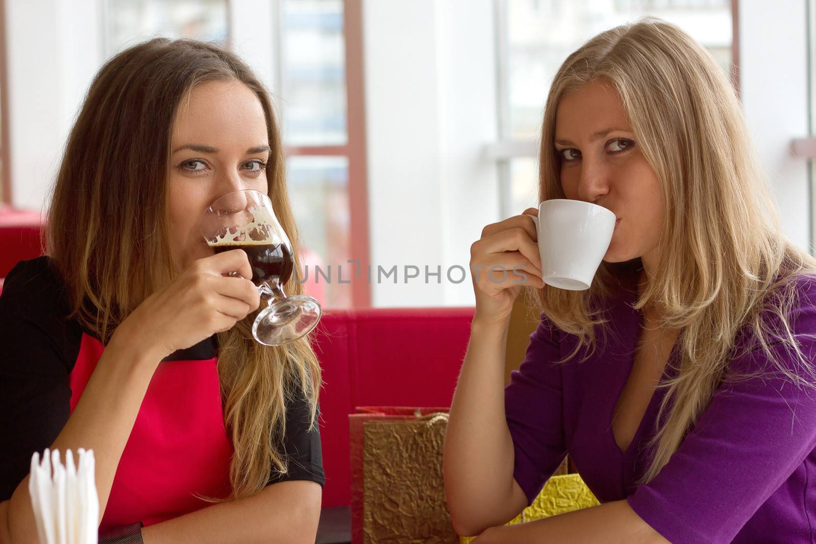 two girls drinking coffee in a cafeteria
